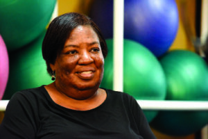 african-american woman smiling during interview in front of brightly colored excersise balls