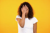 Discontent biracial lady gesturing face palm on camera against yellow background