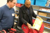 Augusta Elementary School Principal Richard Greer and Todd Holt of Arkansas Blue Cross check out a backpack in the school’s food pantry.