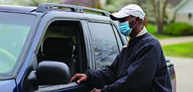 Man leaving in his truck wearing mask